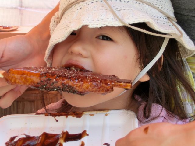 自分で作った五平餅を食べる少女