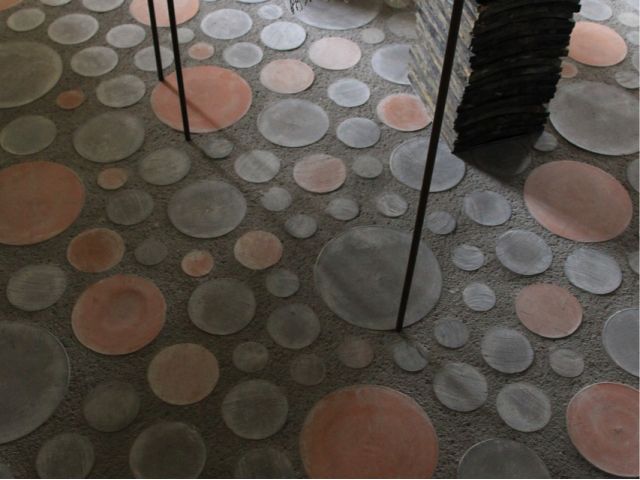 ギャラリーの床の一部にあしらわれた丸い瓦、丸坐。グッドデザイン賞をいただきました。