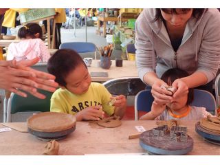 粘土を手でこねながら、器を形作る手びねり作業。