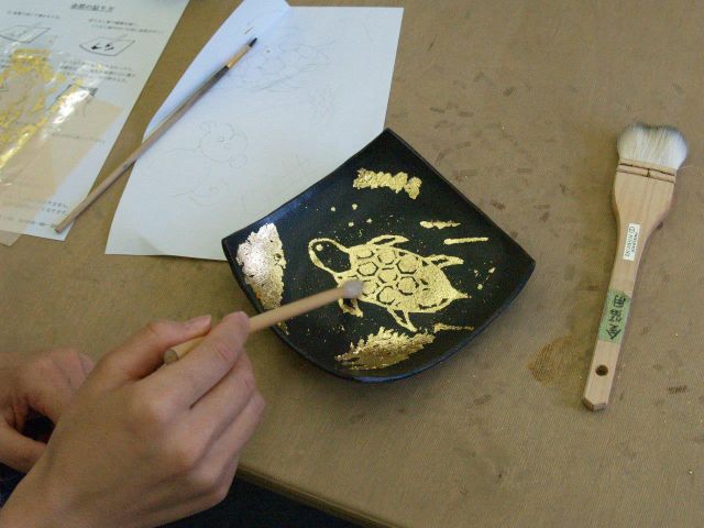 制作中・・・do陶芸館オリジナルの黒いお皿に、好きな絵を書き金箔を貼ります。