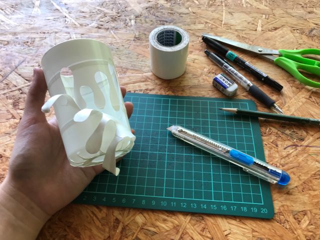 グラスの表面には白いテープでマスキングしてあります。これにデザインを書いて切り抜いていきます。