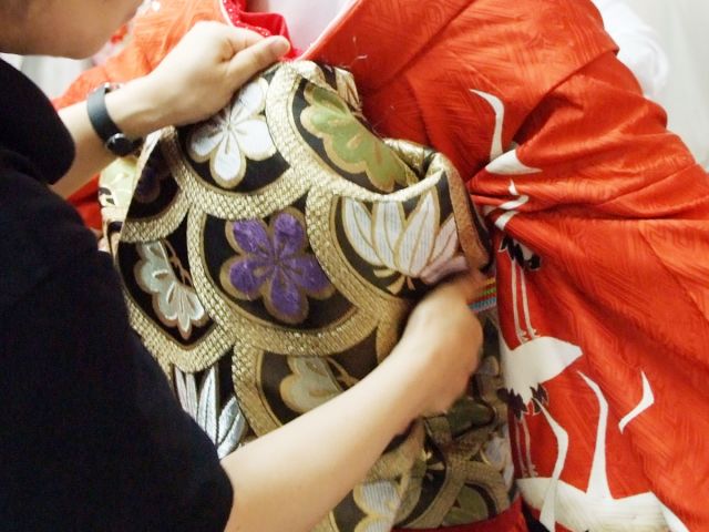舞妓本格着付け◆長ーーーい帯を本格的に結びます。着物と帯を着付けるとずっしりと重みが…。舞妓さんの大変さが少しわかります。