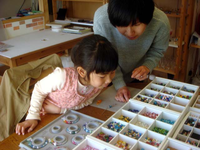 お母さんといろんなビーズやとんぼ玉を選んでいます