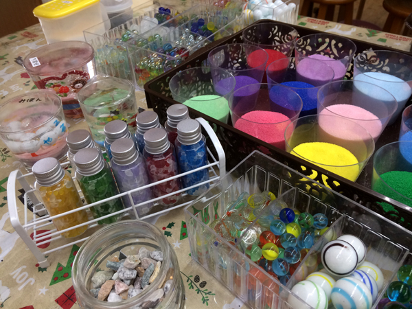 グラスをお選びいただきましたら、どのような作品にするかをイメージして‥色砂・ビー玉・天然石などをアレンジして作ります。