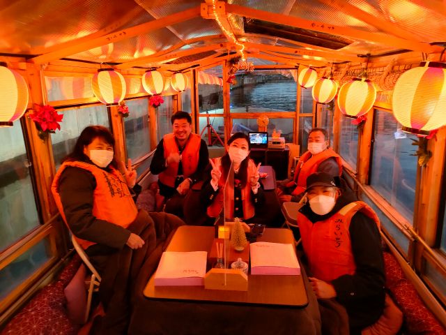 【2023クリスマス仕様こたつ屋形船船内風景】こたつで暖まりながら、工場夜景をお楽しむお客様。
