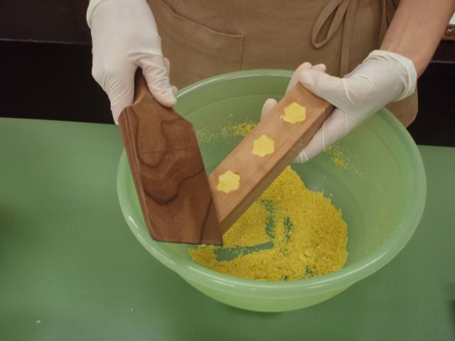 木ベラで軽く端を叩いて振動を加える