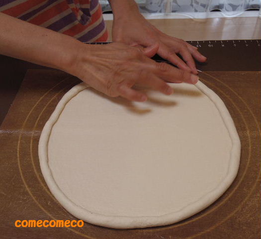 米粉のピザ生地を手でこねて生地が出来たら、ピザの形に丸く伸ばしていきます。