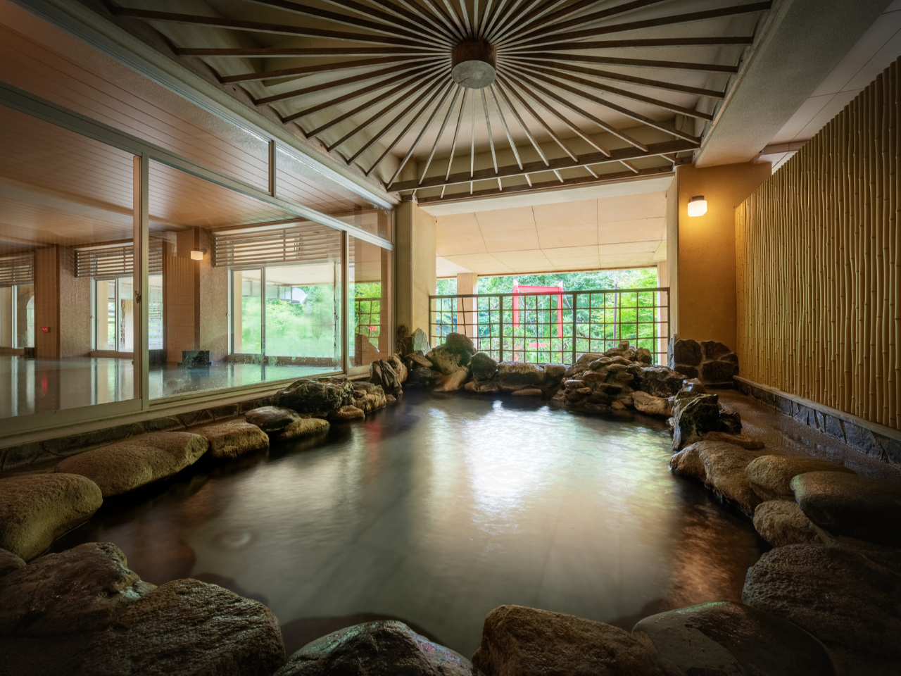 山の湯 岩露天風呂 ※半露天風呂となっており、夜にはライトアップされた庭園を眺めながらご入浴いただけます。