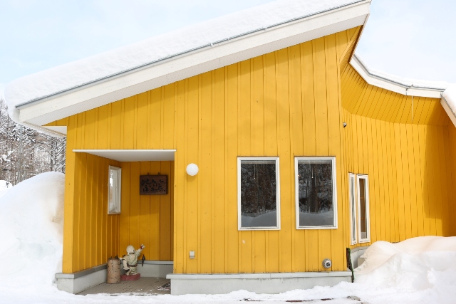 冬のアトリエ。美瑛の森の中に佇む黄色の建物です。