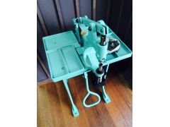 選んだボタンとリベットの打ちつけに使う年代物の打ち機。レバーを足で踏みこむと、上部のアームから力が加わり打ち込む構造。