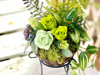 ラタン製の器にアイアンのスタンドがついています。自然にお部屋に馴染むフラワーインテリアです。