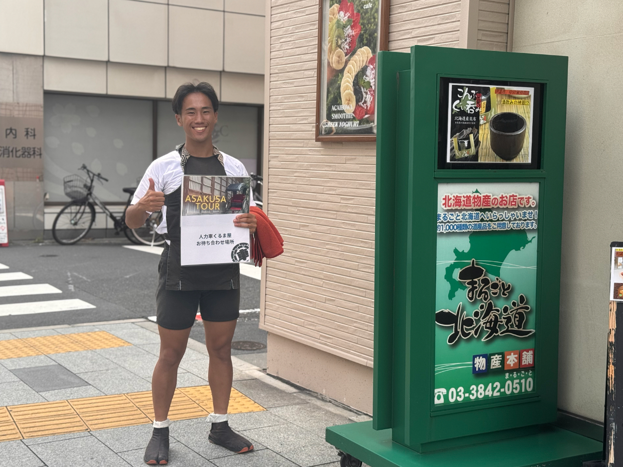 人力車のお待ち合わせ場所の目印は笑顔で看板を持ったスタッフ!!浅草の雷門から徒歩1分の場所になります。