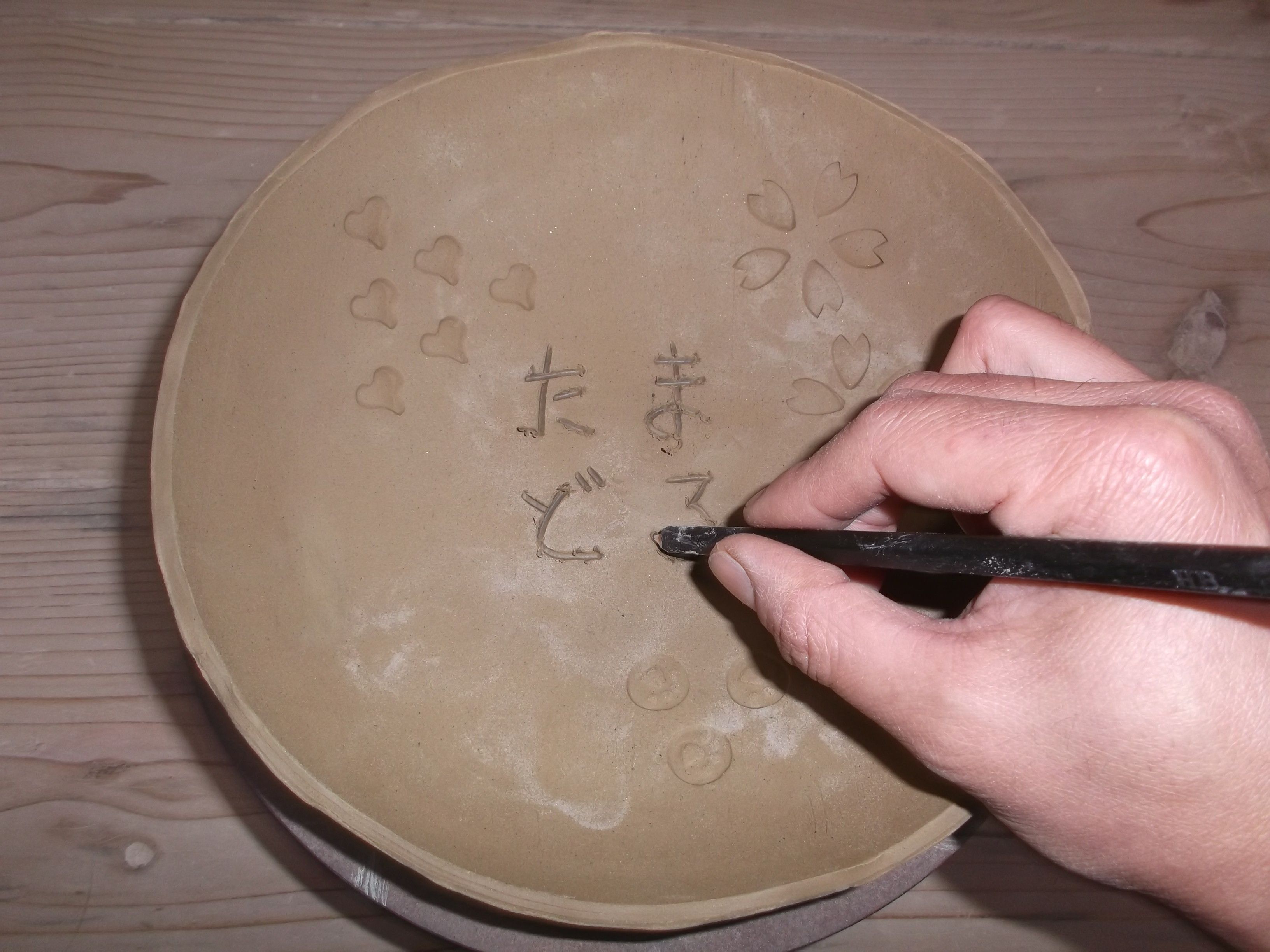 形が整った粘土にハンコや鉛筆で、模様や文字を彫り込みます。2