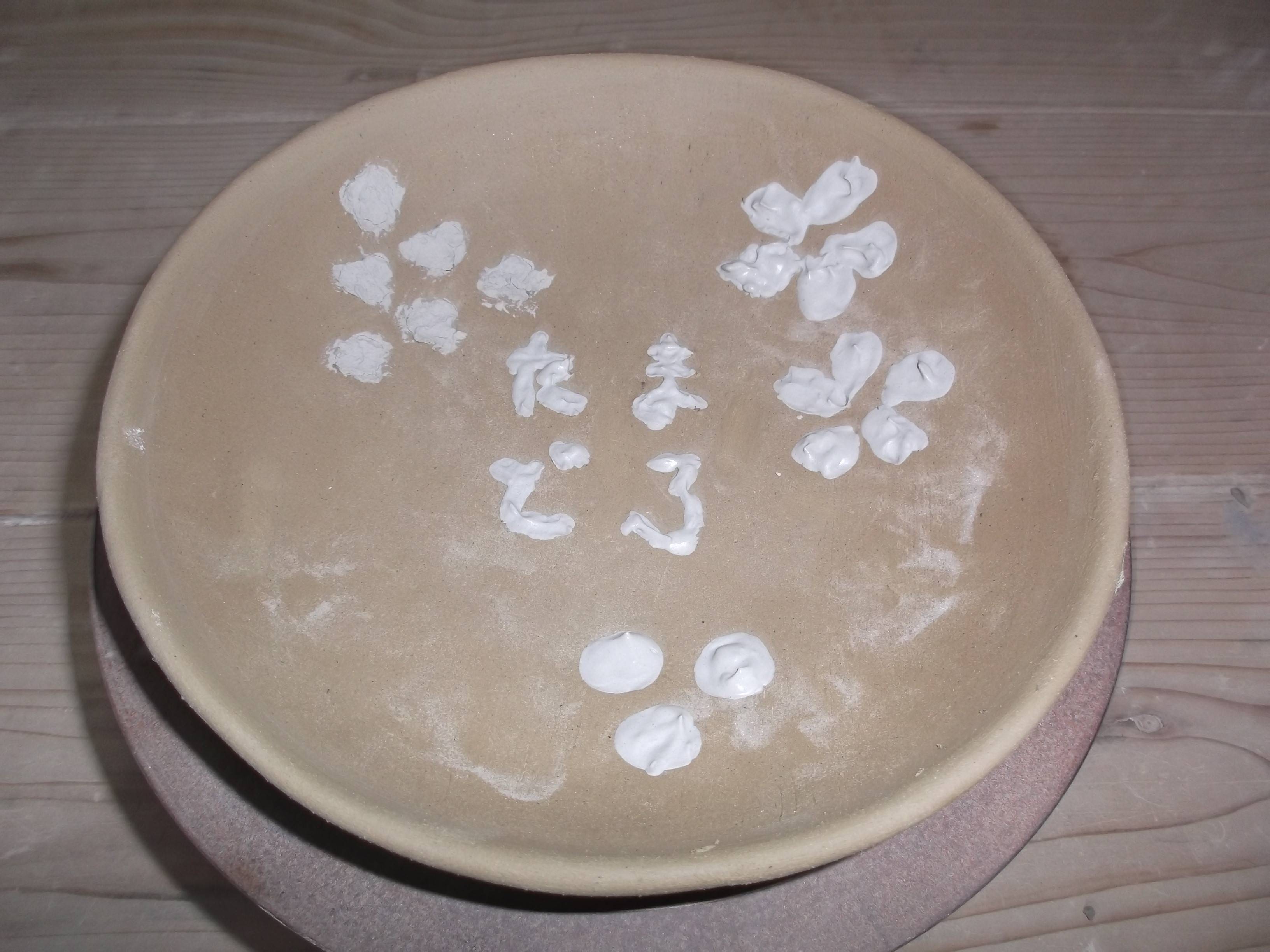 縁(ふち)を整え、彫り込まれた箇所に白化粧土を練り込みます。