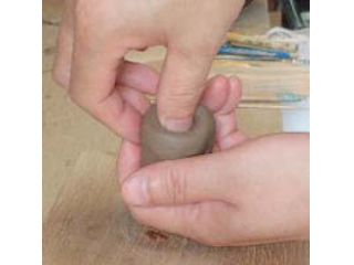 粘土のカタマリの中へ親指を入れて