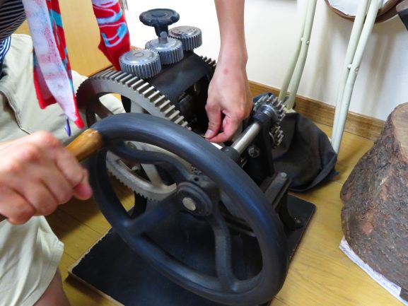 温めた金属、この場合は銀の地金をローラーで延ばしています。