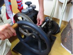 温めた金属、この場合は銀の地金をローラーで延ばしています。