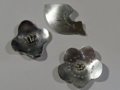 左から「椿」。上は「虫食い木の葉」。下は「梅」のモチーフ。シルバー950の1ミリ厚さの板から作ります。