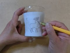 紙に描いておいたイラスト共にマスキングテープを貼り付けて、グラスをカバーします。 ラインに沿ってカッターで切り込みを入れてゆきます。