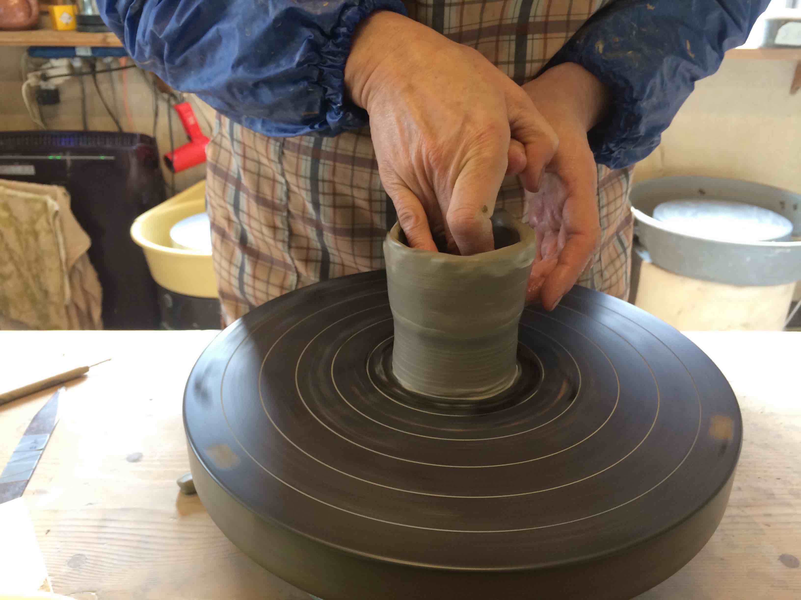 器に水を付けてろくろを回し両手の指で挟みます