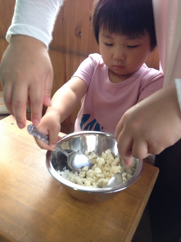 3歳のお子さんでもお母さんと一緒に体験できます。チーズの元をスプーンで細かくくだきます。