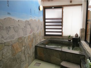 貸切専用風呂(光明湯みなみ家温泉)壁には石を貼った北アルプスの山並みが描かれています。一人用サウナ付き。