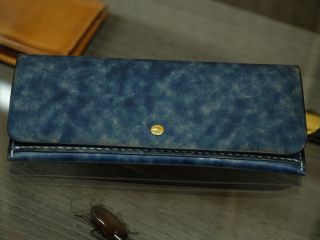 お客様の作品の長財布と、下に見えるのは、ルアー職人さんが作った美しい木のゴキブリです。