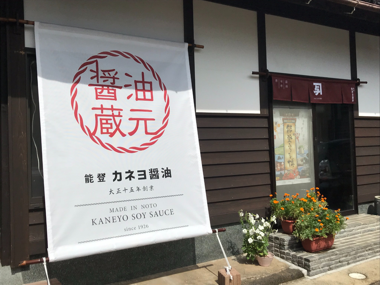 直売所外観。暖簾の前で写真を撮るお客さんも多いです。