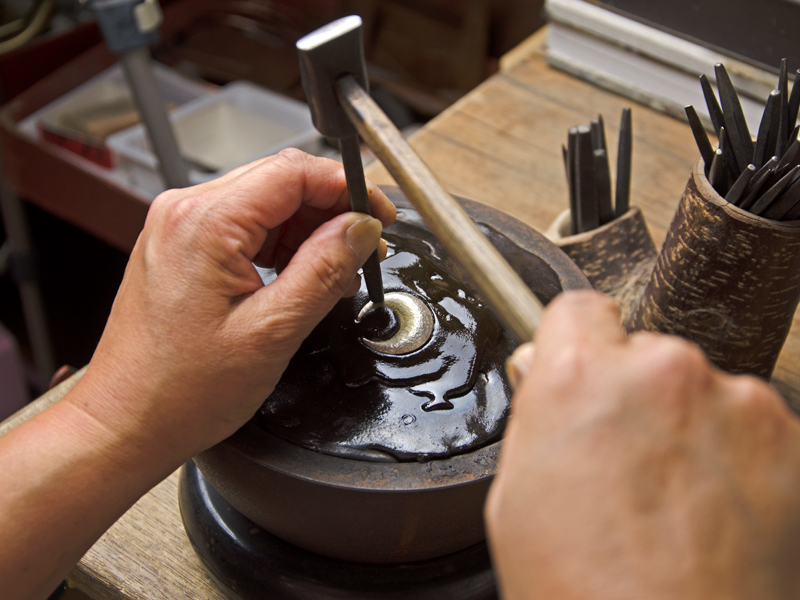 彫金作業:ヤニ台に固定して打ち出し技法をにて加工します。