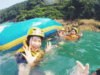 ラフティングツアー仲間と力を合わせて急流を下ります【ダウンリバー中のゆるやかな流れの中で川遊びしてる風景】