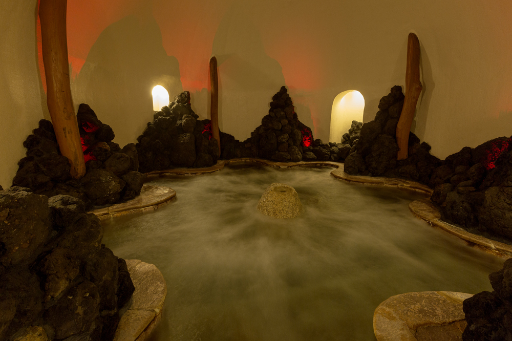 洞窟風呂はドーム型の低温バブル風呂で、溶岩が壁面を覆っています