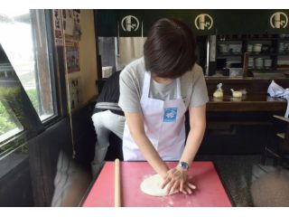 手のひらと麺棒を使ってうどん生地を伸ばします