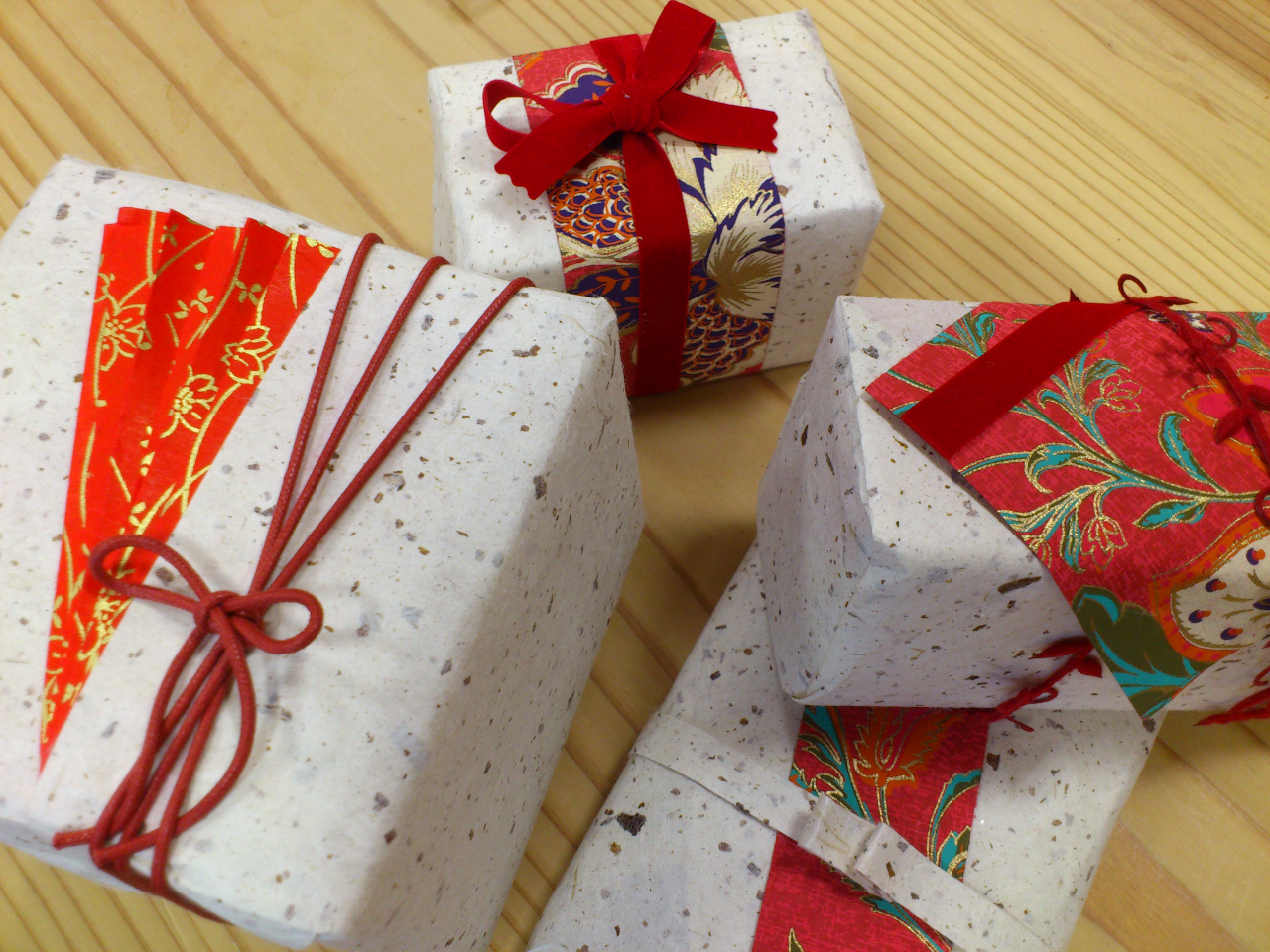 新年のご挨拶を包みました。力が湧く赤なかでも和のテイストたっぷりの落ち着いた紅色を基調に花鳥風月が描かれた洋風和紙を部分的に使って上品に仕上げました。