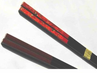 写真の下と同じお箸に、上は漆絵付けした参考例。お箸やスプーンや板などから選んでの絵付けが出来ます。