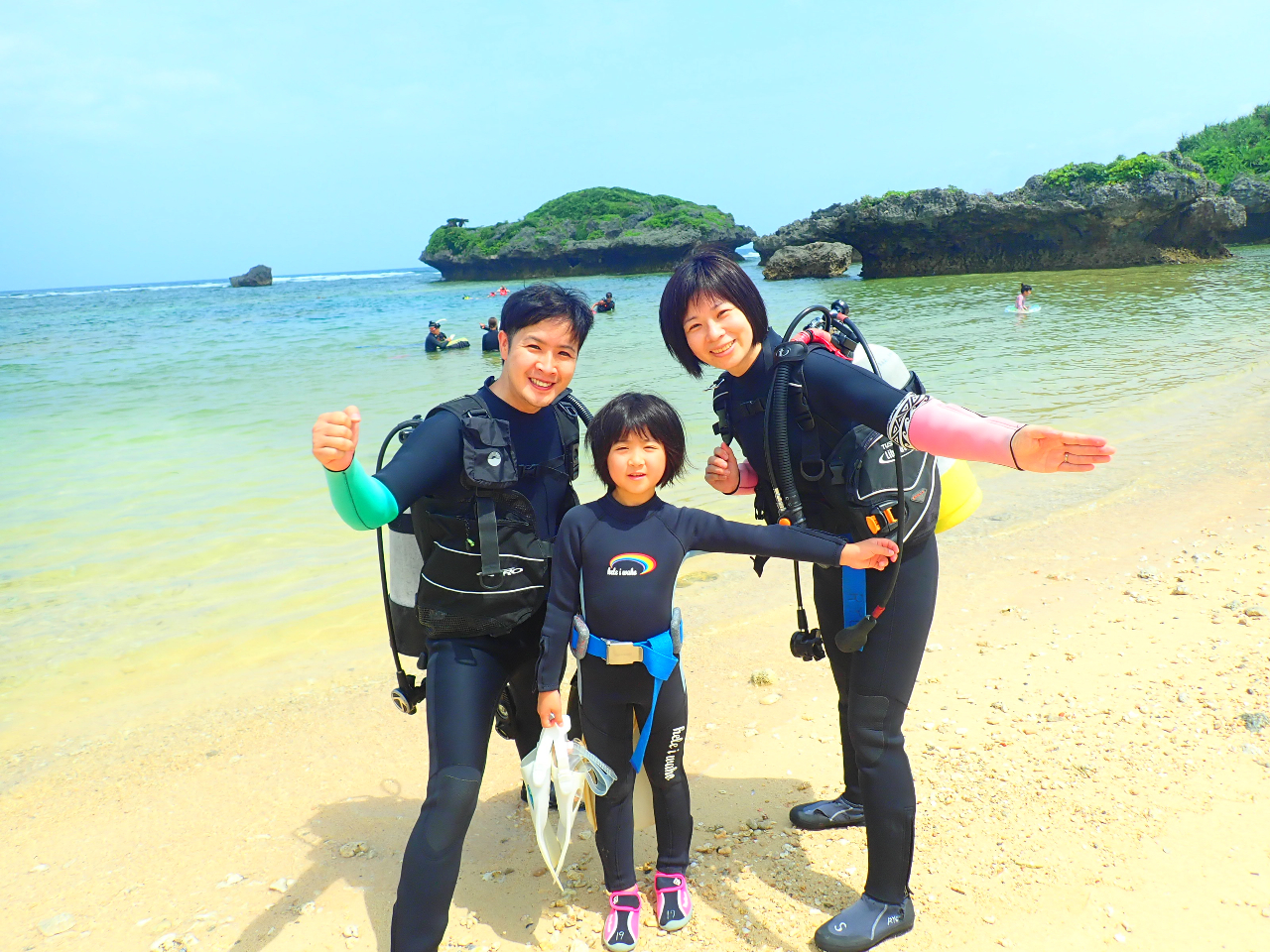 海をバックに記念写真♪お子様の重たい器材はインストラクターが運びます♪水の中に入ると重さは感じなくなります(^ ^)