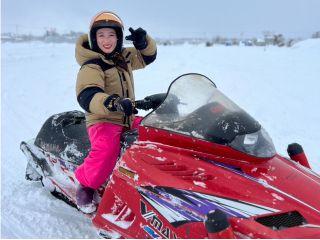 スノーモービル体験の様子です!雪が積もった畑の上を走って遊べます!