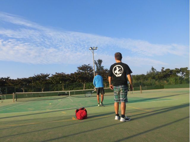 青空の下サーブ調整中、冬場も日中は暖かい日が多く一年中テニスが楽しめます