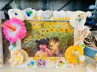 貝やカメ・さかな、ハイビスカスや琉球ガラスのかけらのパーツが含まれているフォトフレーム貝細工体験♪お気に入りのフォトフレームを作って、思い出の写真を飾ろう♪