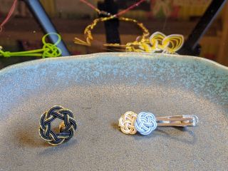 体験で作る水引 左:相生結び(ピンズ) 右:梅結び(ネクタイピン)