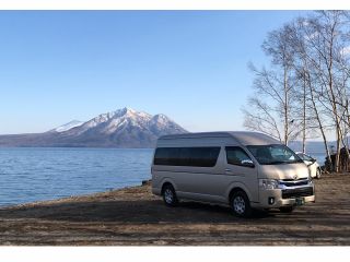 ジャンボタクシーのハイエースグランドキャビン。4〜8名様でご利用いただきます。支笏湖と恵庭岳をバックに。(早春の景色)