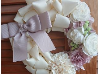 白を基調にエレガントに作成されたリボンリース