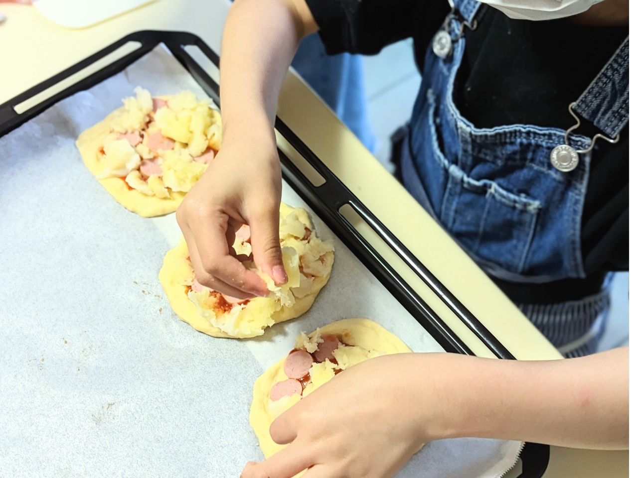 ミニピザの具は、ピザソース、じゃがいもとウィンナー、そしてチーズを用意。お子さんが一番こだわる作業です。