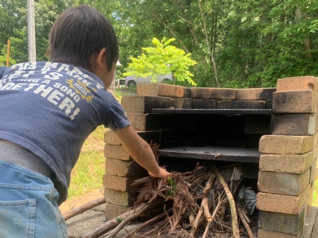 山から拾ってきた焚き木で火をつけてピザを焼きます。