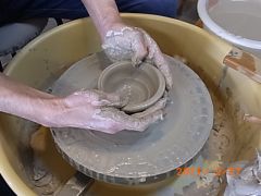 粘土の中心に両親指で穴を開けてから広げていきます