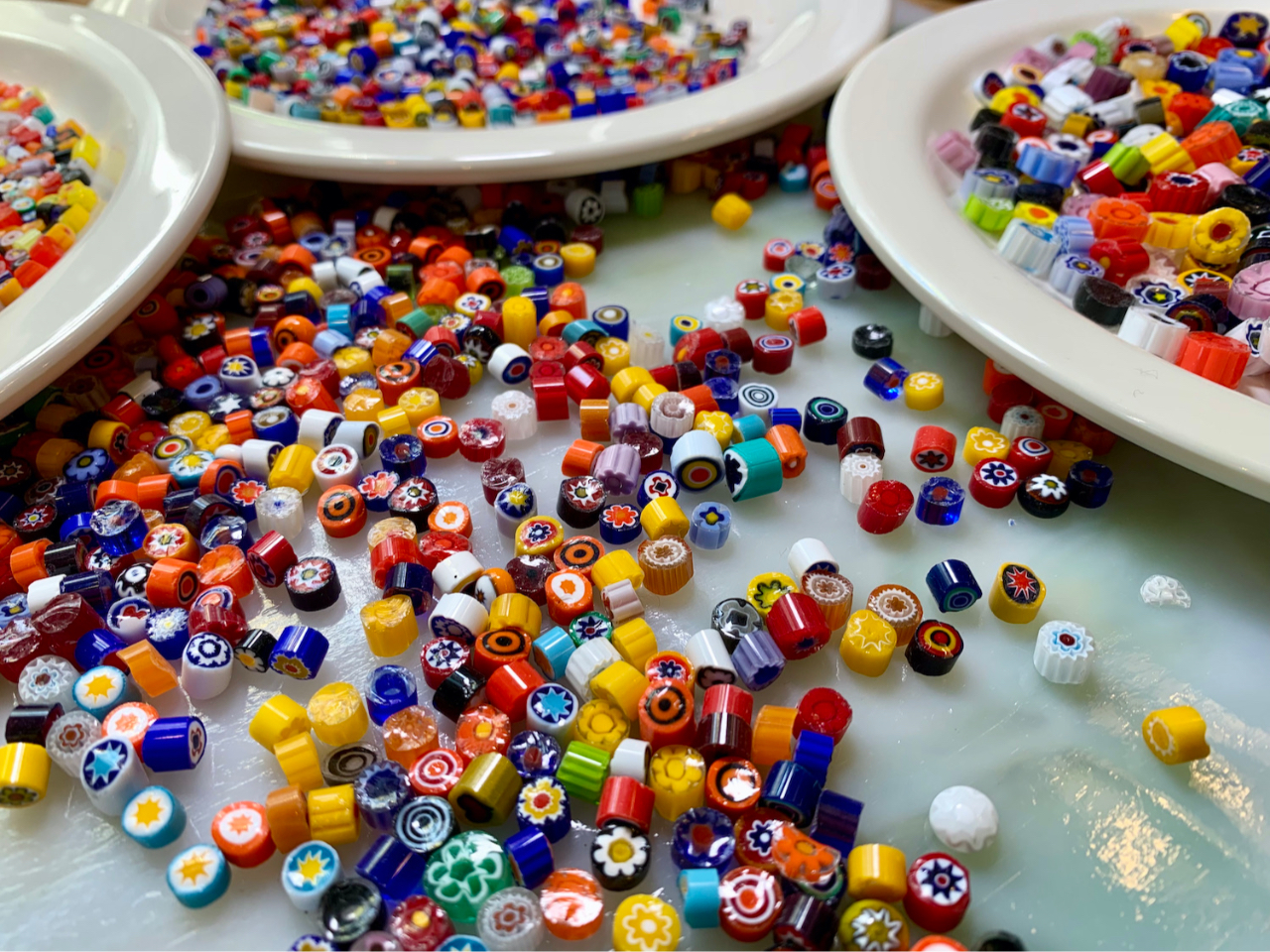 さまざまな大きさとカラフルな丸いガラス(ミルフィオリ)を板ガラスに並べます