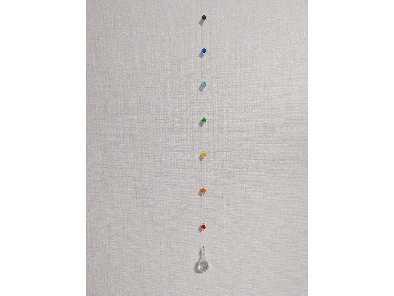 20ミリミラーボール型のクリスタルガラスと虹色のガラスビーズをテグスに通して作る窓につるすタイプのサンキャッチャー。長さ約55cm。長さはお好みで変更可能です。