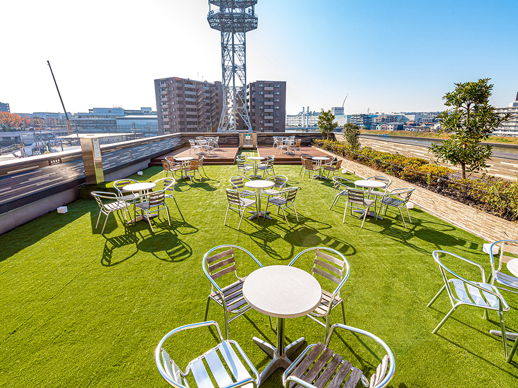 ツリーブレイクガーデンの奥 広々した屋上庭園で鶴見川の自然を感じ解放感をお楽しみください。 BARAKUで購入された商品もお召し上がりいただけます。