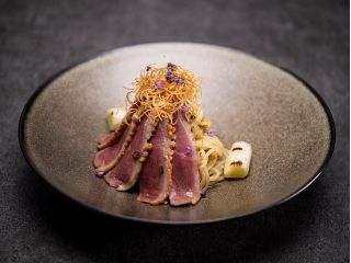 “鴨南蛮”をオマージュして創作したパスタ料理。香辛料を効かせた和風ベースのマリネで仕上げた河内鴨と、香ばしく焼いた白葱を合わせた和風パスタです。