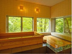 窓の外には森の緑が広がる本館の檜の湯。檜の香りが情緒たっぷりのひと時を叶えてくれる。