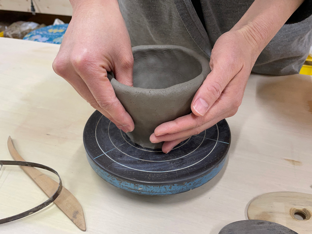 お茶碗やカップは「玉づくり」で。丸めた粘土を手回しろくろの上で形にしていきます。